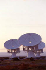 Three radio telescopes, dishes turned towards the sky.